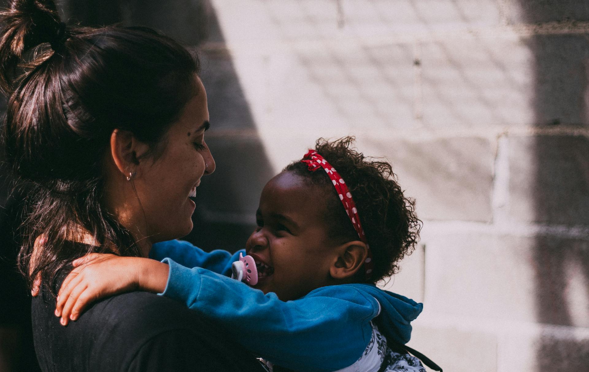 A woman holding a baby in a blue jacket