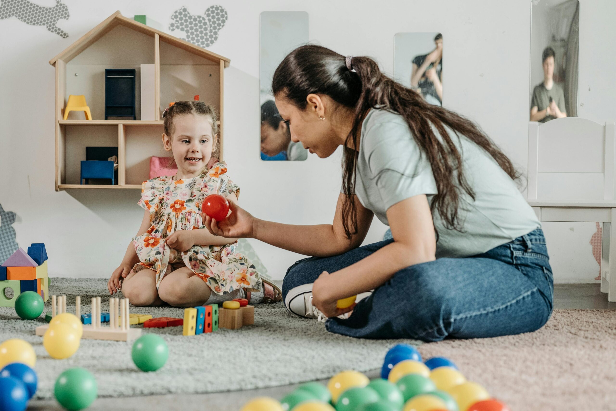 woman on the floor playing with a child