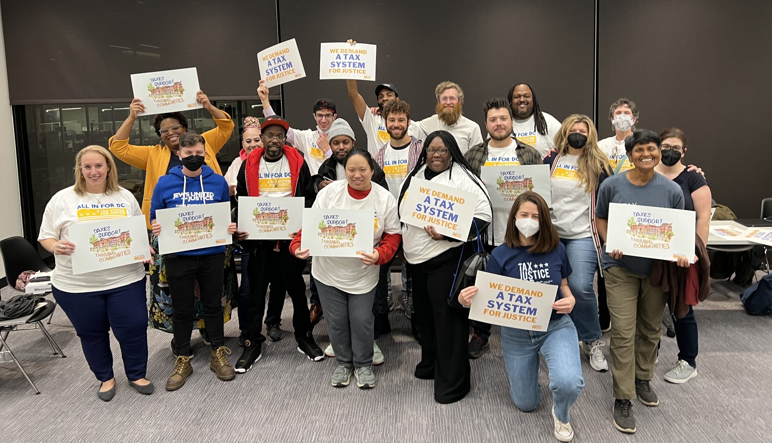 A group of people from the Just Recovery DC campaign holding signs that read "A Tax System for Justice"