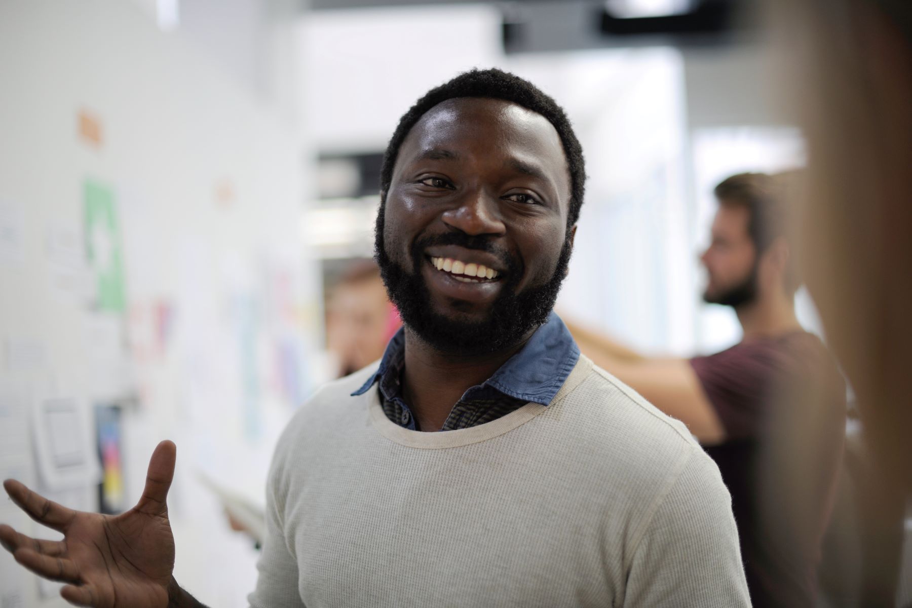 Man smiling in a classroom in front of a whiteboard